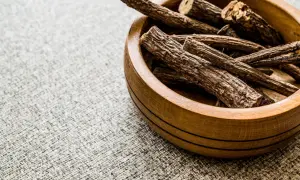 Racines de réglisse dans un bol en bois, évoquant les bienfaits du réglisse pour la santé.