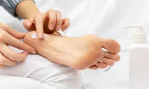 Application de crème hydratante sur un pied sec. Un tuto pieds au sec pour des pieds doux et sains.