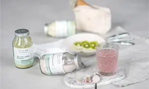 Verre de boisson rose et poudre de collagène pour une routine beauté. Le plaisir de boire du collagène.