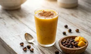 Smoothie orangé saupoudré de cannelle, avec des noisettes et des dés de mangue. Un délice pour profiter du guarana bienfait.