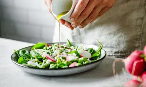 Salade fraîche avec vinaigrette versée, un plat sain pour soulager le foie. Épinards, radis, fèves edamame et fromage émietté.