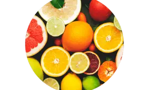 Un assortiment d'agrumes coupés et entiers, un aliment bon pour la peau, baignant dans une lumière vive.