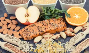 Assortiment d'aliments sains : saumon, amandes, fruits, graines. Une alimentation équilibrée est essentielle, surtout en cas d'hyperthyroïdie alimentation à éviter.