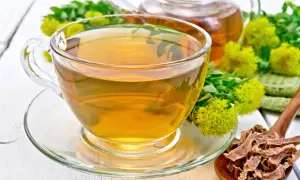 Une tasse de thé ambré, des fleurs de rhodiola et des racines séchées. Attention, la rhodiola peut présenter un danger si mal utilisée.