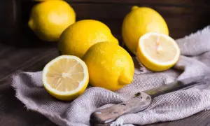 Citrons frais, coupés et entiers, sur un tissu, évoquant un remède de grand-mère contre le rhume de cerveau.