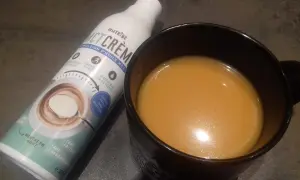 Bouteille d'émulsion d'huile MCT et une tasse de boisson. Attention à l'huile MCT, danger potentiel si mal utilisée.