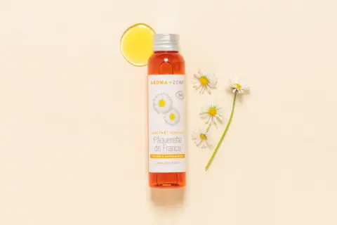Flacon d'huile de pâquerette Aroma-Zone, avec des pâquerettes. Attention, huile de pâquerette danger potentiel pour certaines peaux.