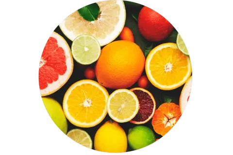Un assortiment d'agrumes coupés et entiers, un aliment bon pour la peau, baignant dans une lumière vive.