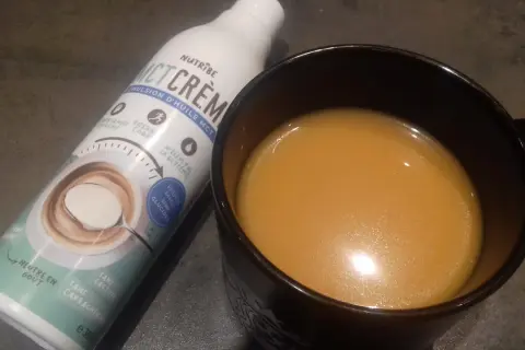 Bouteille d'émulsion d'huile MCT et une tasse de boisson. Attention à l'huile MCT, danger potentiel si mal utilisée.