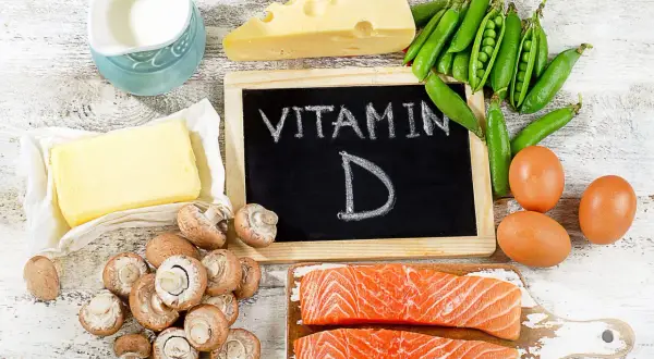 Assiette de saumon, œufs, champignons, pois, fromage, beurre et lait, tous des aliments riches en vitamine D.