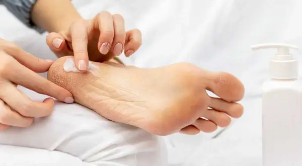 Application de crème hydratante sur un pied sec. Un tuto pieds au sec pour des pieds doux et sains.