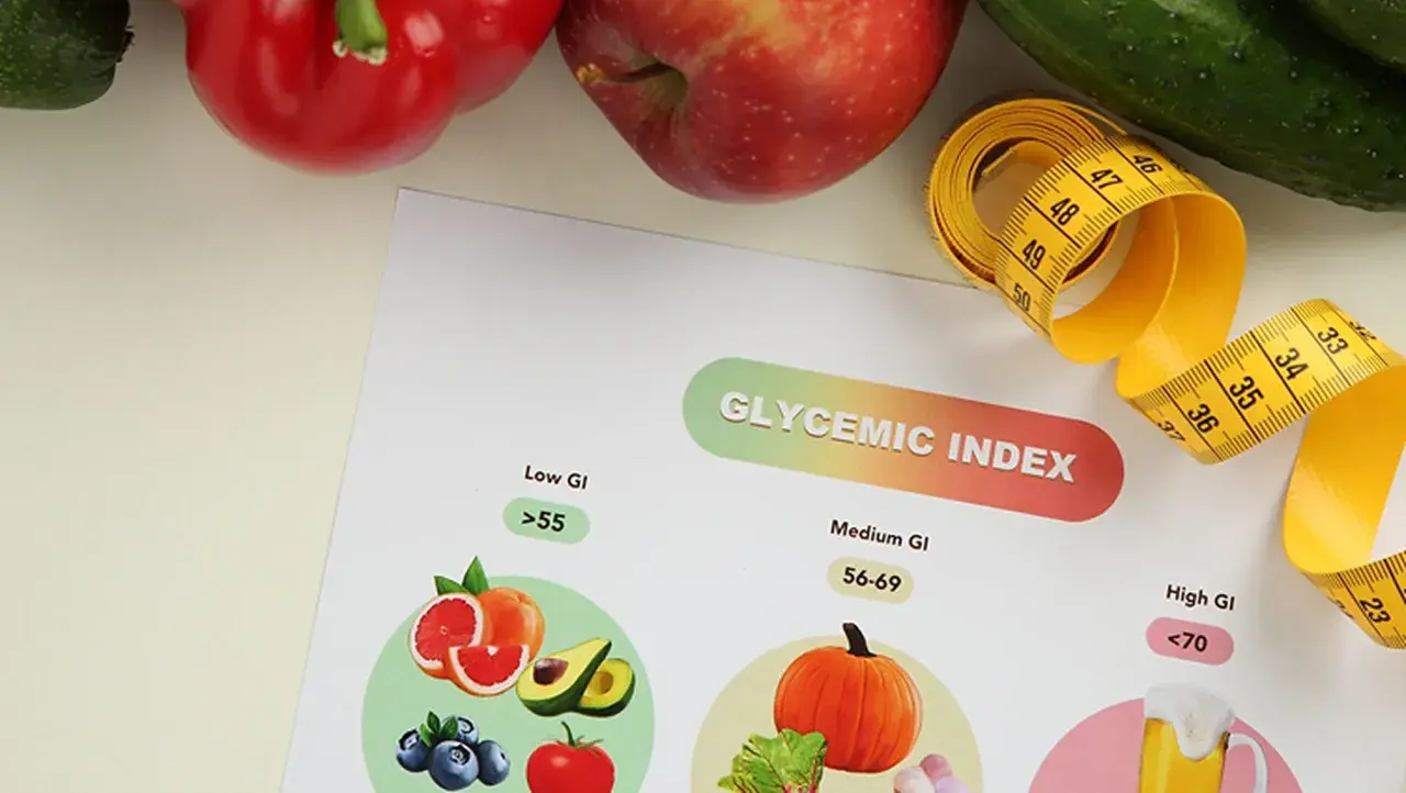 Tableau sur l'index glycémique des aliments, avec des fruits et légumes. Un mètre ruban jaune symbolise la mesure.