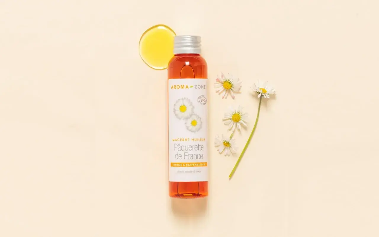 Flacon d'huile de pâquerette Aroma-Zone, avec des pâquerettes. Attention, huile de pâquerette danger potentiel pour certaines peaux.