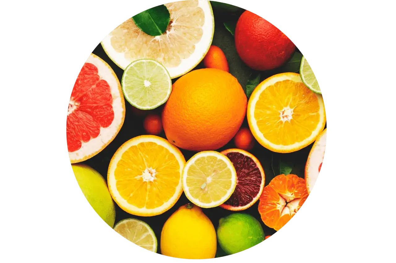 Un assortiment d'agrumes coupés et entiers, un aliment bon pour la peau, baignant dans une lumière vive.