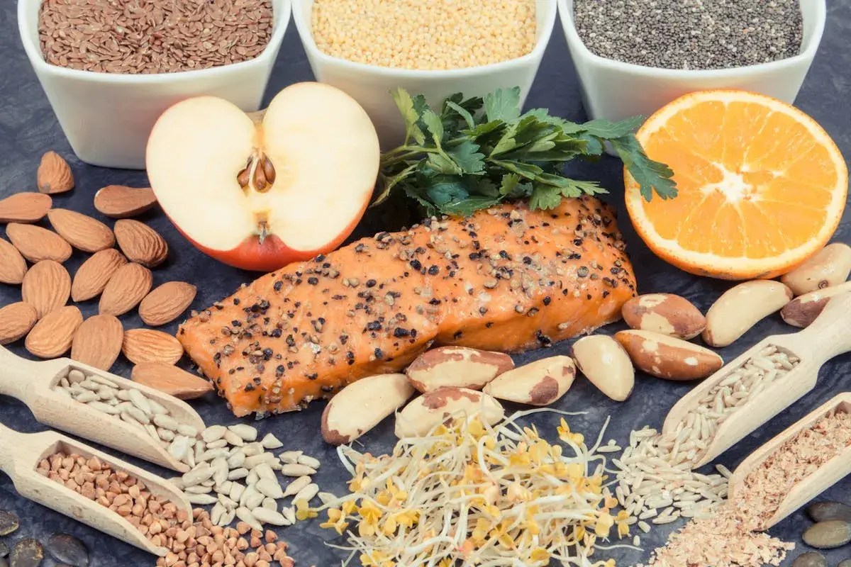 Assortiment d'aliments sains : saumon, amandes, fruits, graines. Une alimentation équilibrée est essentielle, surtout en cas d'hyperthyroïdie alimentation à éviter.