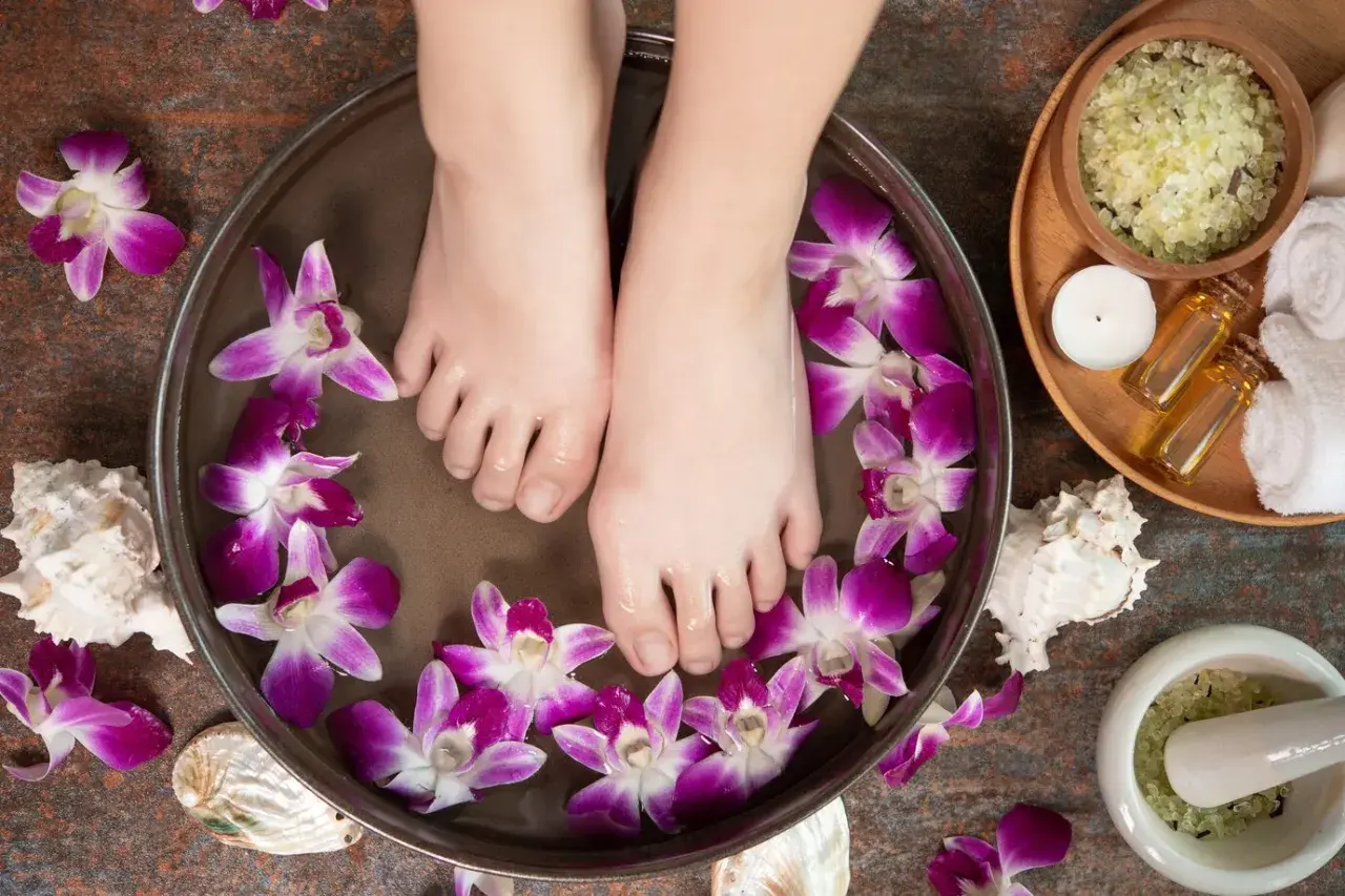 Pieds dans un bain de fleurs d'orchidée et de sel d'Epsom pour un moment de détente.