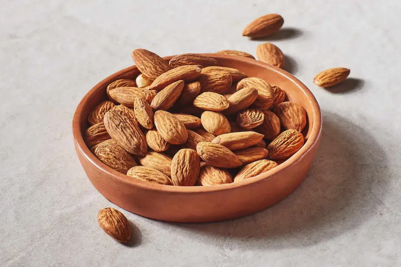 Un bol rempli d'amandes, rappelant leurs nombreux bienfaits pour la santé. Ces noix croquantes sont une excellente source de nutriments.