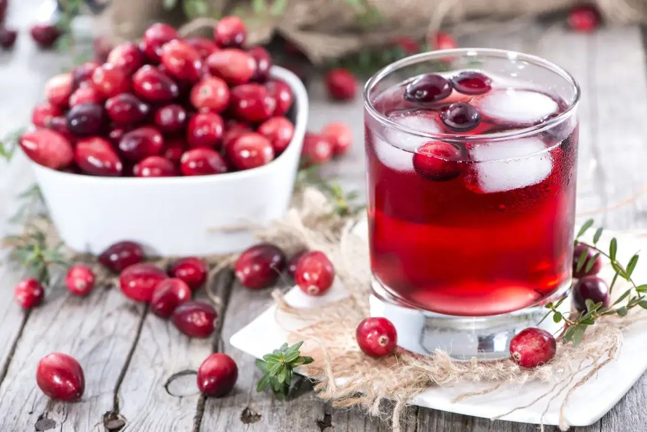 Jus de cranberries rafraîchissant avec des fruits frais. Une aide naturelle contre l'infection urinaire.