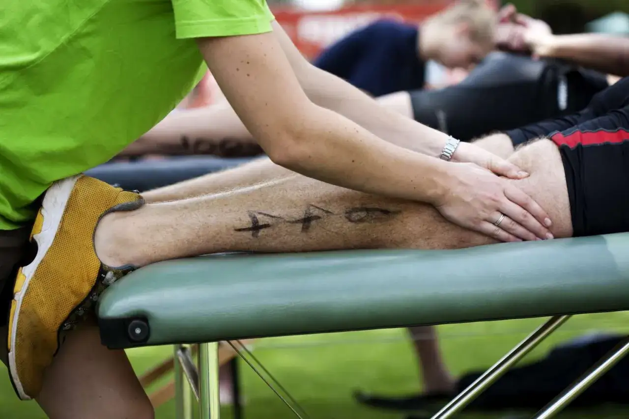 Massage des jambes apr&egrave;s une course, un rem&egrave;de miracle contre les courbatures. Des marques noires sur la peau indiquent les zones &agrave; traiter.