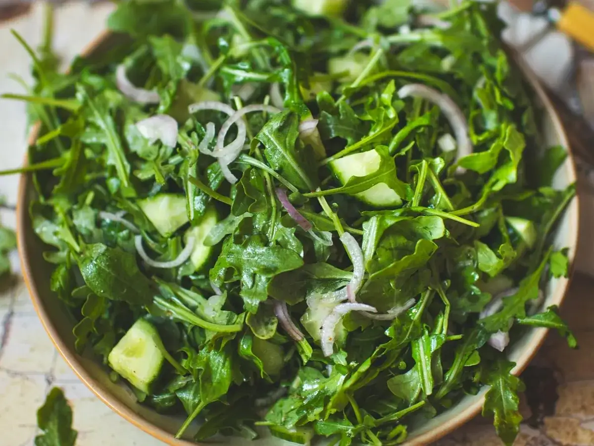 Salade fra&icirc;che et croquante de roquette, concombre et oignon rouge, pr&ecirc;te &agrave; &ecirc;tre d&eacute;gust&eacute;e.