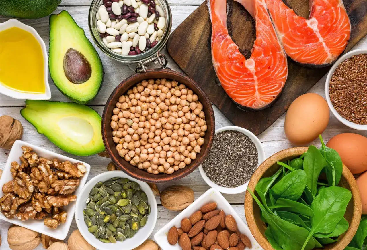 Assiette colorée avec saumon, avocat, noix, graines de chia, épinards, œufs et légumineuses. Ces aliments sont riches en oméga 3 DHA, excellents pour la santé.