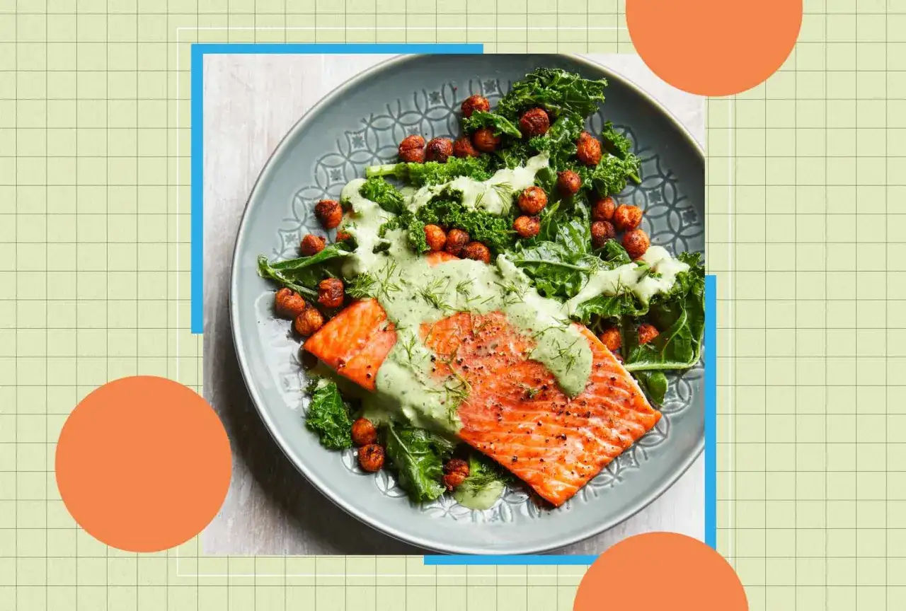 Un filet de saumon avec une sauce verte crémeuse, servi sur un lit de chou frisé et de pois chiches rôtis. Idéal pour savoir que manger le soir pour une bonne digestion.