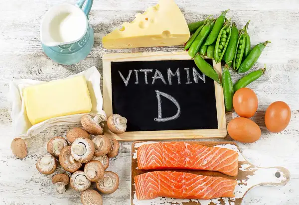 Assiette de saumon, œufs, champignons, pois, fromage, beurre et lait, tous des aliments riches en vitamine D.