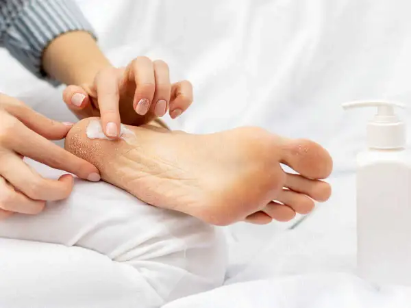 Application de crème hydratante sur un pied sec. Un tuto pieds au sec pour des pieds doux et sains.