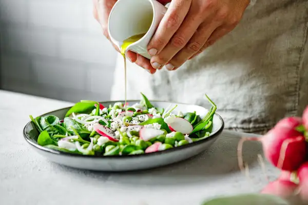 Salade fraîche avec vinaigrette versée, un plat sain pour soulager le foie. Épinards, radis, fèves edamame et fromage émietté.