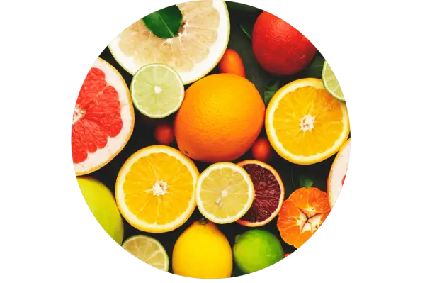 Un assortiment d'agrumes coupés et entiers, un aliment bon pour la peau, baignant dans une lumière vive.